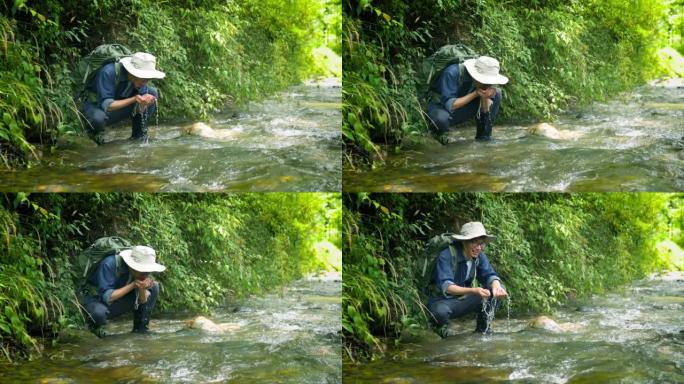 男性徒步旅行者喝溪流中的水