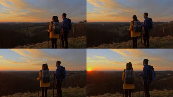 徒步旅行夫妇在日落时欣赏风景优美的山景