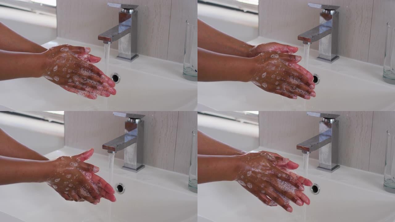 非裔美国妇女在家里的浴室水槽里洗手的特写
