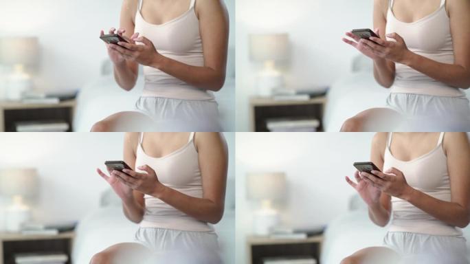 一名妇女在家中床上使用智能手机的4k视频片段