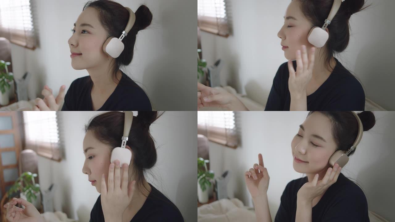 千禧一代亚洲女子戴着耳机在家听音乐不寒而栗
