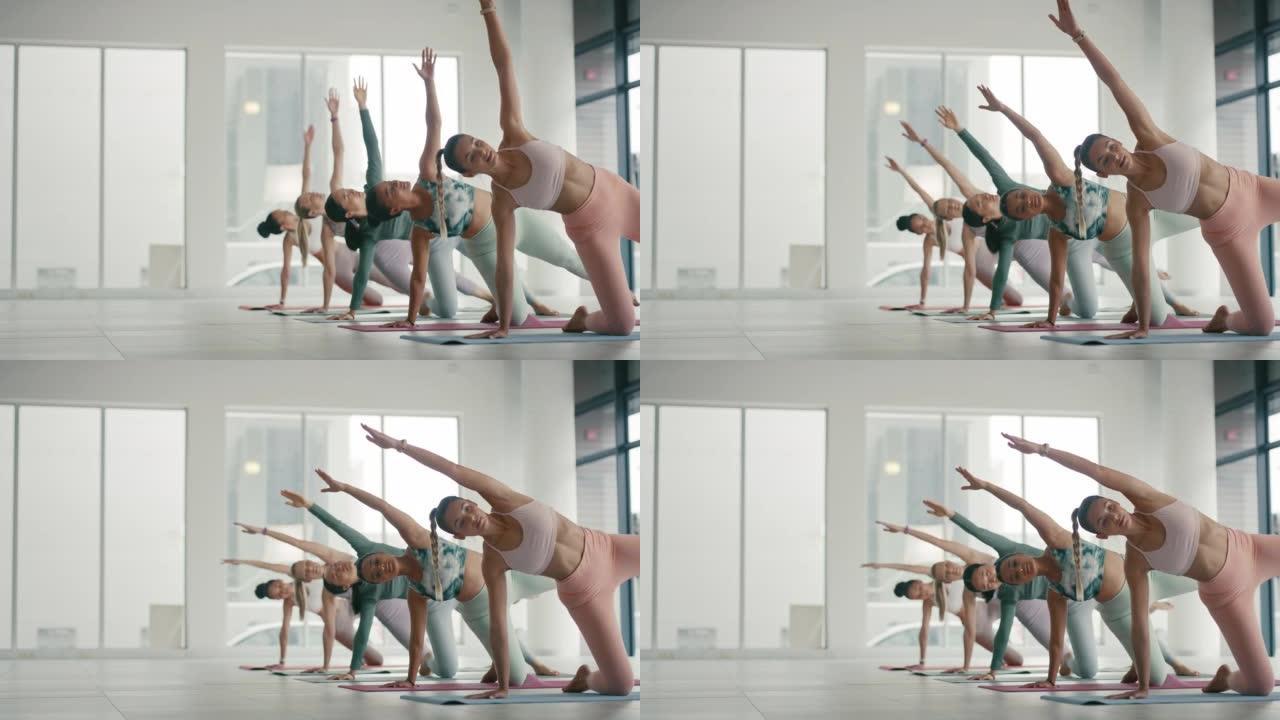 一群活跃的女性在现代健身房一起做瑜伽。健康和运动的女性在健康中心锻炼和训练。健身女士伸展和练习平衡