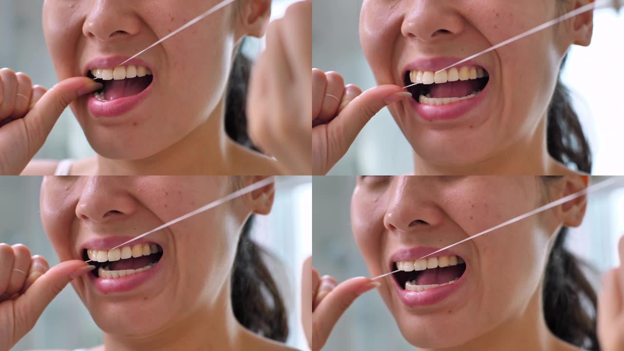 女人用牙线洁牙，同时从齿间取出剩余的食物