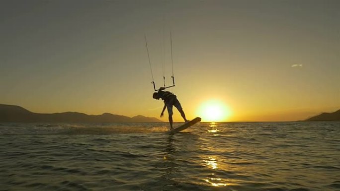 慢动作: 风筝冲浪者跳跃并将水溅入相机
