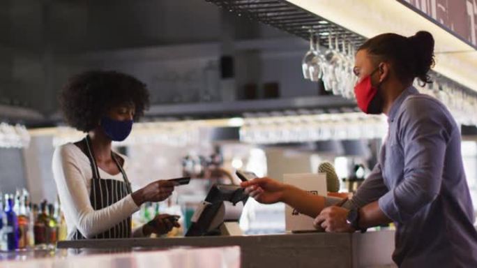 混血男子给非裔美国女咖啡馆工作人员信用卡以付款