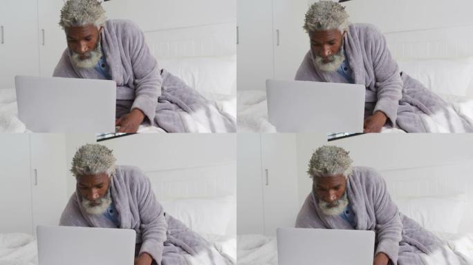 老人在家中床上使用笔记本电脑
