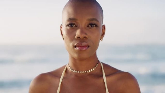 平静，海洋和来自马达加斯加的黑人妇女的脸在大自然中感到放松。秃头，美丽而年轻的人凝视着，准备在暑假里