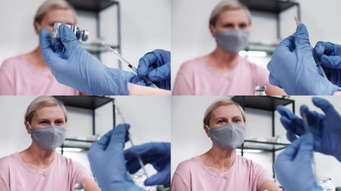 超级特写，医生妇女的手在蓝色保护手套拿着注射器和疫苗烧瓶为高级患者。