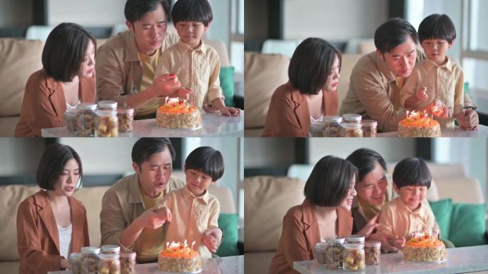 亚洲华裔父亲用打火机点燃生日蜡烛准备在客厅为儿子唱生日歌庆祝生日