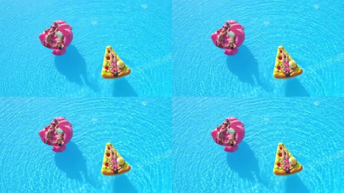 空中: 三个朋友在无忧无虑的暑假期间在五颜六色的漂浮物上放松