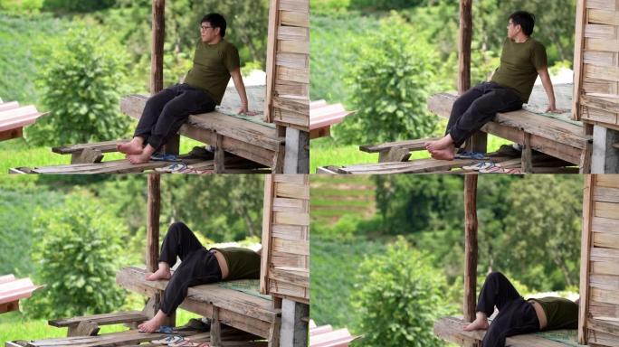亚洲男子在完成农业工作后在房屋露台上放松身心