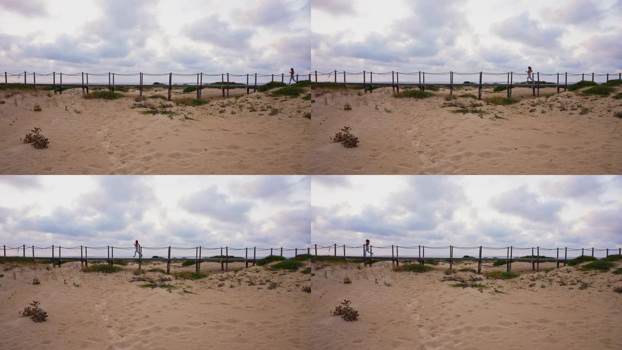 在海滩上的木板路上奔跑的无法识别的女运动员的广角静态镜头