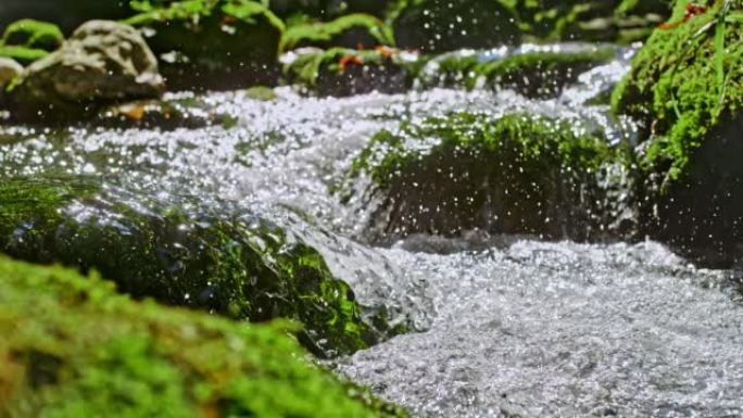 来自急流的超级SLO MO水流过覆盖着苔藓的岩石