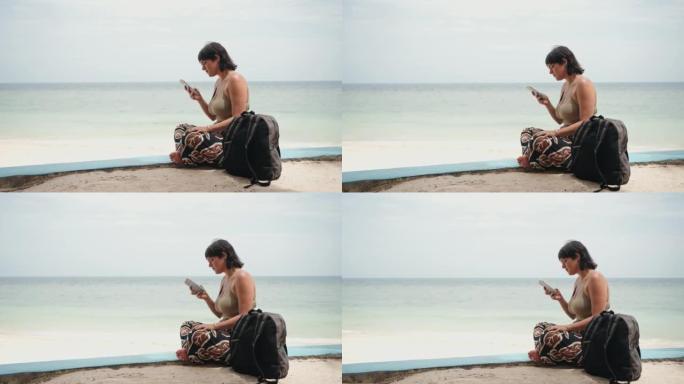 女人在海滩上使用电话