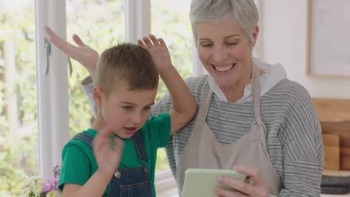 祖母和孩子使用智能手机进行视频聊天小男孩与奶奶共享假期周末，喜欢在家与孙子在手机上聊天