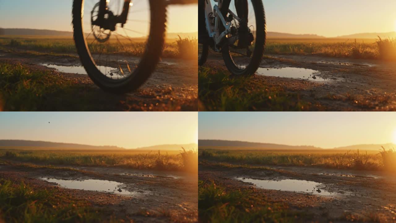 SLO MO无法识别的MTB骑自行车的人在日落时沿着泥泞的小路骑行