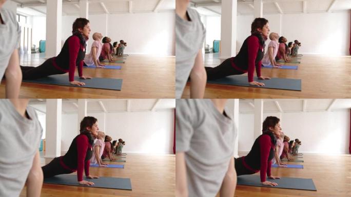 一群运动的人在健身工作室练习瑜伽课