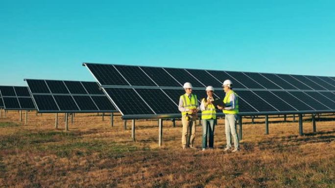 太阳能电池板附近的工程师。太阳能发电厂工人，太阳能行业概念。