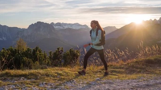 健康的女人保持健康的生活方式，日落时在山上徒步旅行