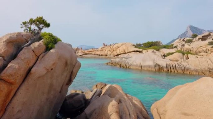 撒丁岛沿岸在岩石上行走的人们的景色。