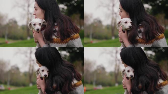 在夏日，年轻女子在户外拥抱她最喜欢的蓬松白狗。
