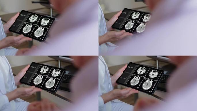 无法识别的医生向患者显示数字平板电脑中的CAT扫描结果