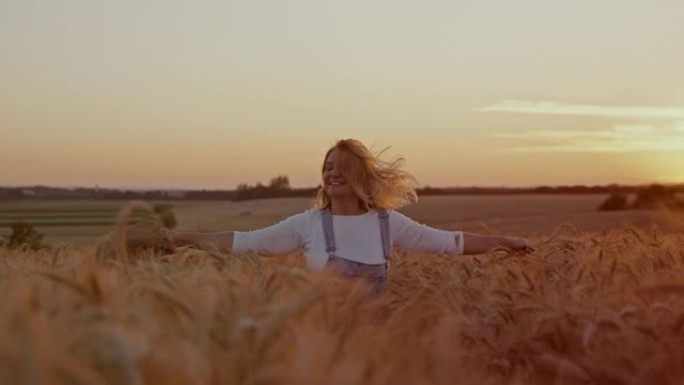 无忧无虑的女人在麦田上奔跑时拿着小麦和草帽