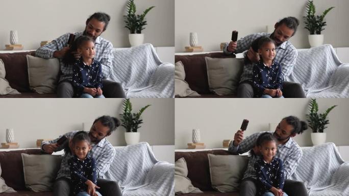 有爱心的非洲父亲梳理小女儿的卷发