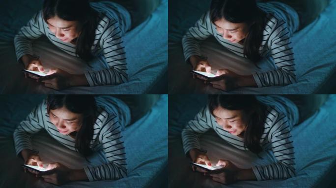 年轻女子躺在家里的床上使用电话
