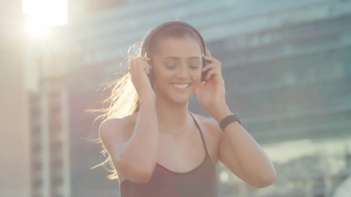 4k视频片段，一名运动的年轻女子在外面散步时戴着耳机