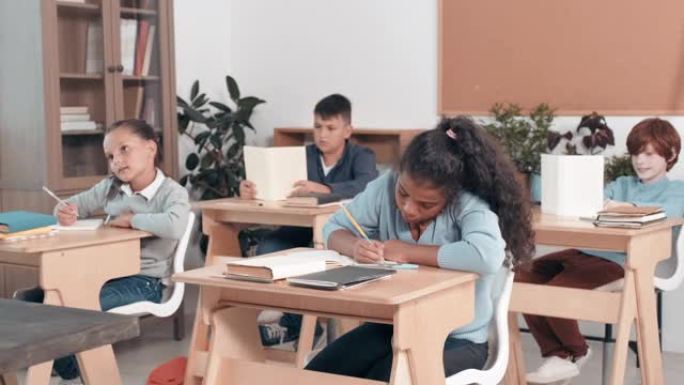 孩子们坐在教室的桌子上