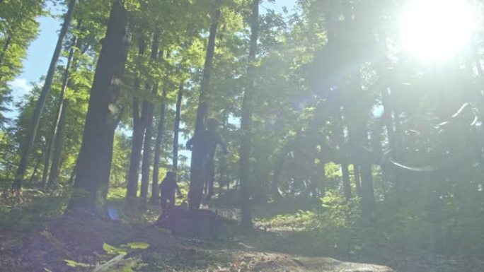 SLO MO MTB骑自行车的人跳过森林中的坡道