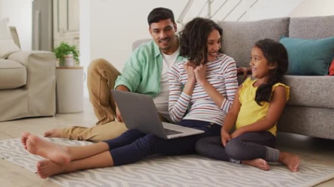 快乐的西班牙裔父母和女儿坐在笔记本电脑上