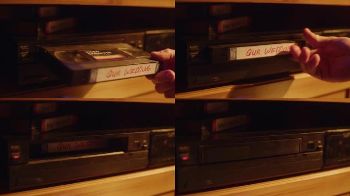 复古90年代技术概念。一个人在播放器中插入VHS盒式磁带的特写镜头，并带有家用摄像机的怀旧婚礼镜头。