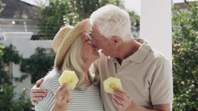 4k视频片段，一对高级夫妇站在外面吃了一片菠萝