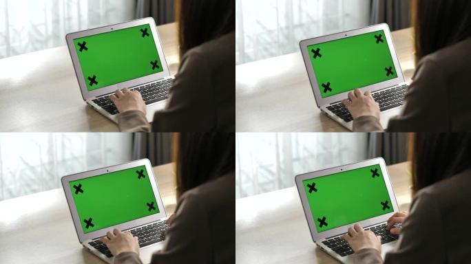 女人使用带有绿屏显示的笔记本电脑