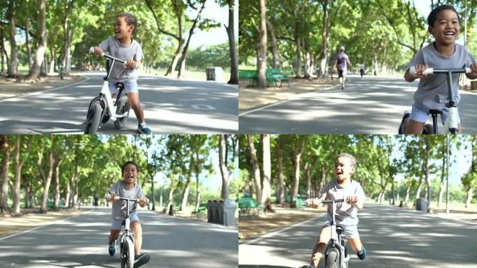 快乐蹒跚学步的男孩骑平衡自行车
