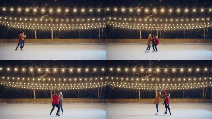 冬季仙境: 滑冰夫妇在一个神奇的夜晚在溜冰场上玩得开心。美丽的雪落下，灯光闪耀。恋爱中的男孩和女友，