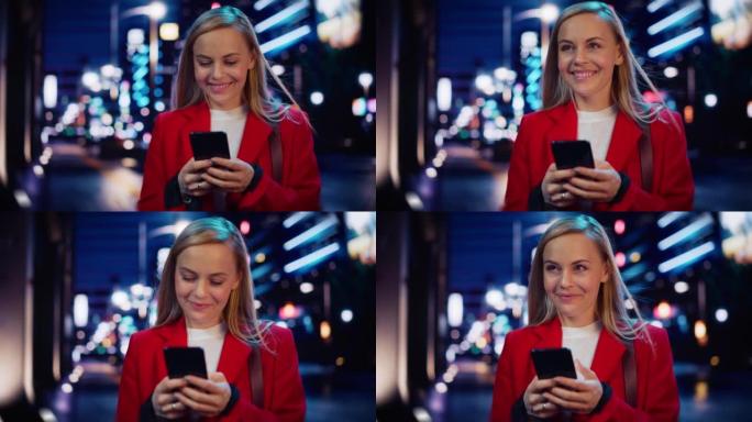 美丽的女人站着，在城市街道上使用智能手机，霓虹灯在夜间闪耀。自信微笑的美丽女性使用手机。中等跟踪电影