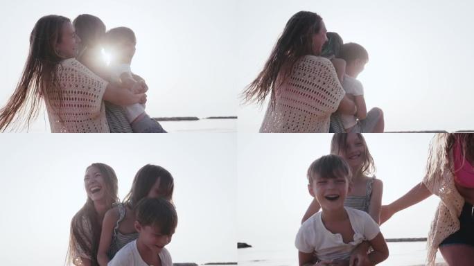 爱情和家庭度假，年轻快乐的母亲在夏天的沙滩上慢动作中抱着两个快乐的孩子旋转