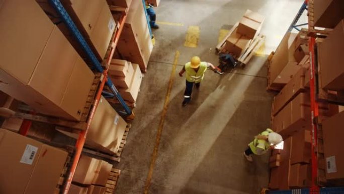 自上而下的提升视图: 工人使用手动托盘车移动纸板箱，在零售仓库的货物成排的货架之间行走。人们在产品配