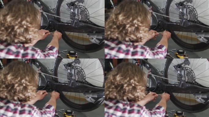 专注的高加索人在车库里用工具修理自行车