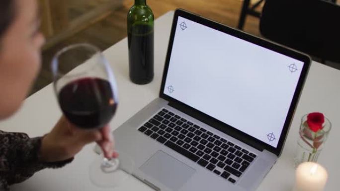 白人妇女在使用带复制空间的笔记本电脑进行视频聊天的浪漫晚餐