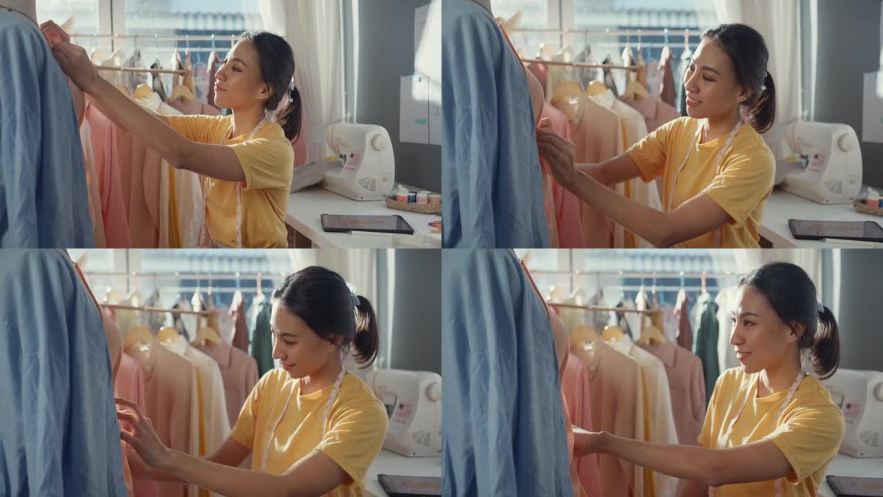 专业开朗的年轻亚洲女士裁缝用针将面料附着在模特身上，在商店里创造新的服装系列设计。定制行业概念。定制