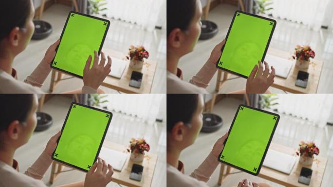 女人使用带有绿色屏幕的数字平板电脑