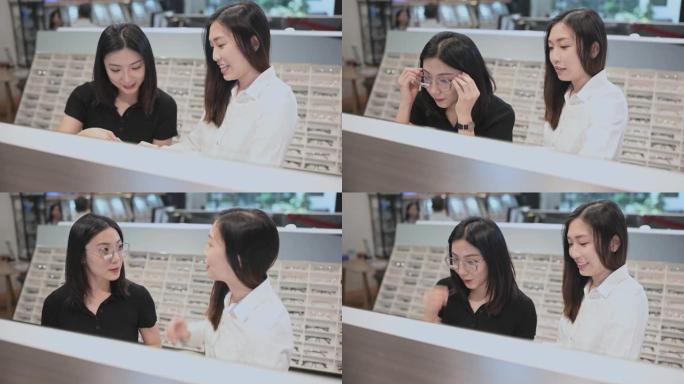 亚洲华人女售货员在眼镜店向她的女性顾客在镜子前试戴眼镜解释