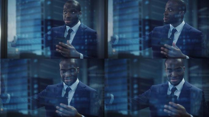 成功的黑人商人的肖像穿着西装站着，用智能手机看着窗外。微笑的股市投资经理正在完成交易。从外面拍摄
