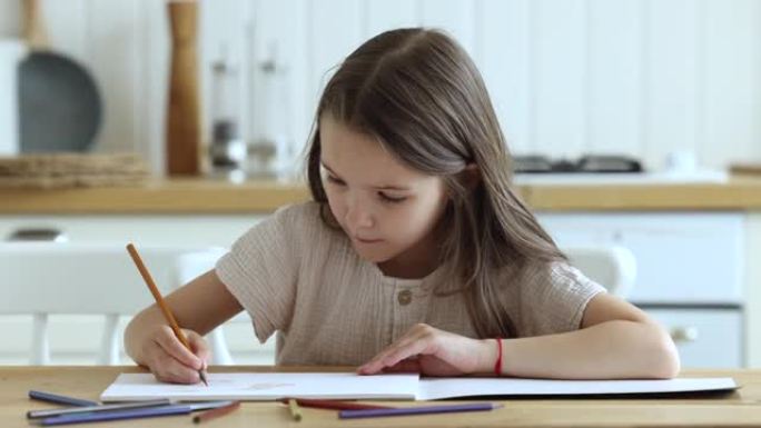 漂亮的小女孩用彩色铅笔在素描本上画画