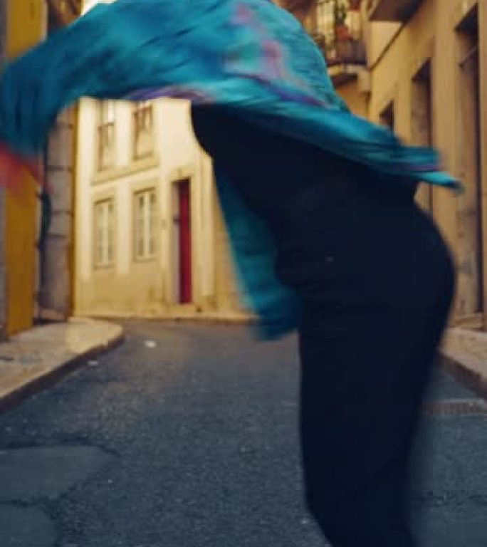 垂直屏幕: 穿着时尚衣服的美丽年轻成年女子在城市老城区的街道上积极跳舞嘻哈。在安静的小镇街道上的城市