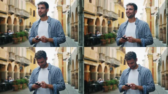 在阳光明媚的日子里，一个年轻的微笑男子正在使用智能手机发送消息，拨打电话或在老城区的互联网上导航。概